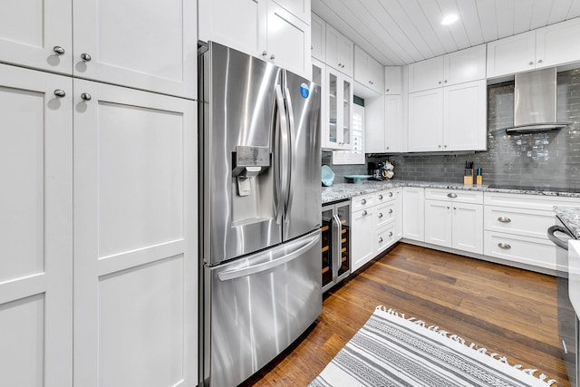 kitchen with wall chimney range hood, white cabinetry, stainless steel refrigerator with ice dispenser, and dark hardwood / wood-style floors