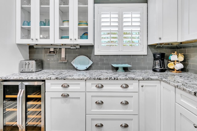 kitchen featuring white cabinets, tasteful backsplash, and wine cooler