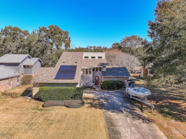 view of front facade featuring a front yard and solar panels