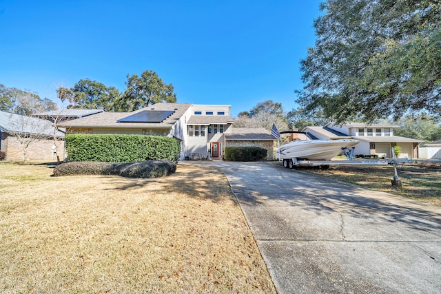 view of front of home featuring a front yard and solar panels