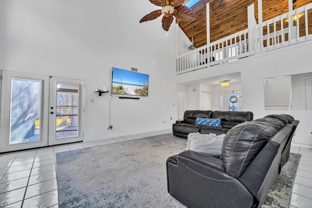 living room with wood ceiling, high vaulted ceiling, ceiling fan, and light tile flooring