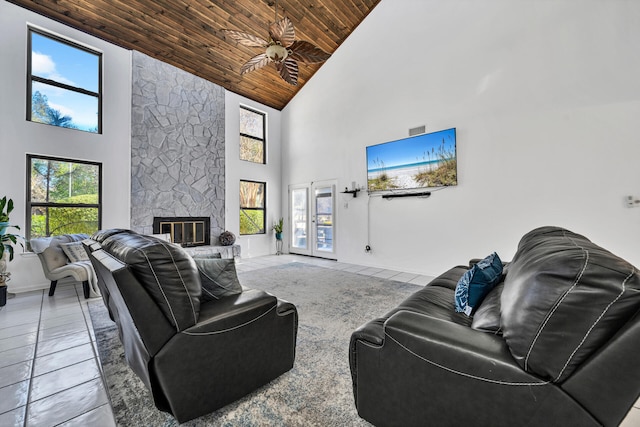 tiled living room featuring high vaulted ceiling, wooden ceiling, and a stone fireplace