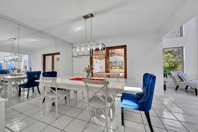 tiled dining space featuring french doors and an inviting chandelier