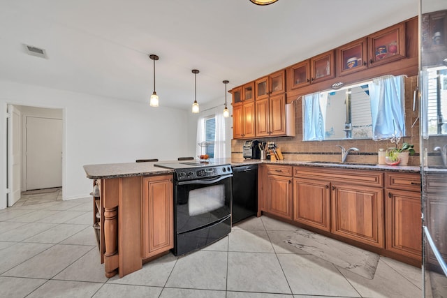 kitchen with black appliances, dark stone countertops, sink, pendant lighting, and light tile floors