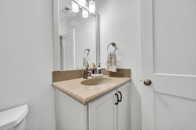 bathroom with vanity with extensive cabinet space and toilet