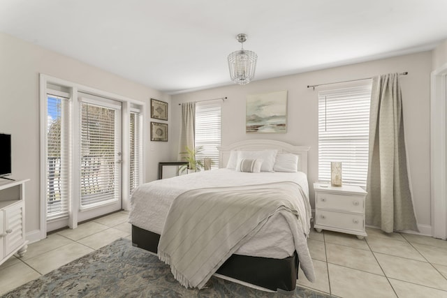 tiled bedroom with a notable chandelier and access to exterior