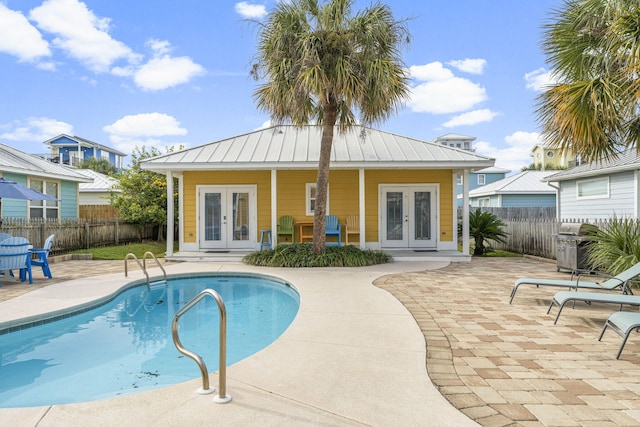 view of swimming pool featuring french doors and a patio