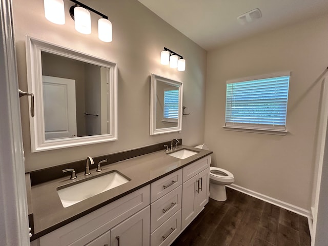 bathroom with toilet, hardwood / wood-style floors, and double sink vanity