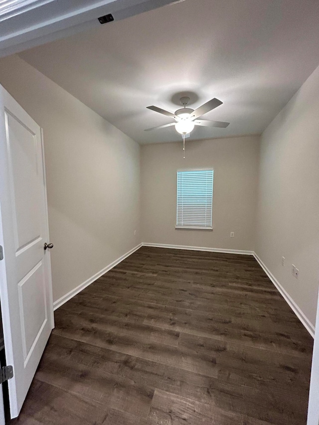 spare room with dark wood-type flooring and ceiling fan