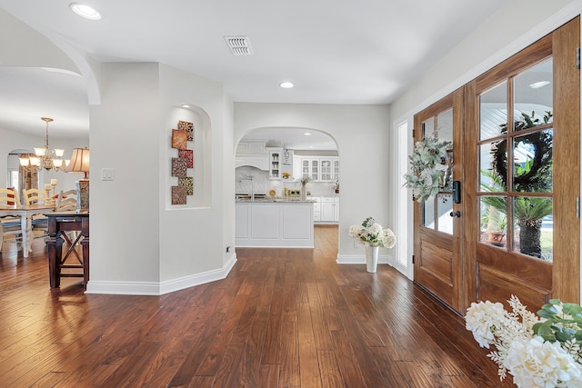 foyer entrance featuring an inviting chandelier and dark hardwood / wood-style flooring