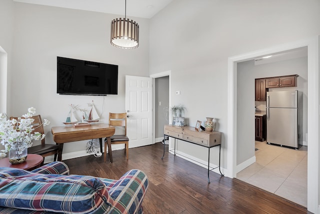 living room featuring a towering ceiling and light wood-type flooring