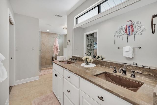 bathroom with vanity, a shower with shower door, and tile patterned flooring