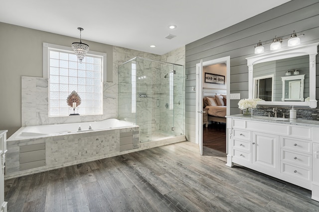 bathroom with hardwood / wood-style flooring, vanity, independent shower and bath, and a chandelier