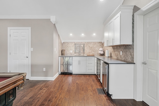 kitchen featuring dark hardwood / wood-style floors, wine cooler, white cabinets, decorative backsplash, and crown molding