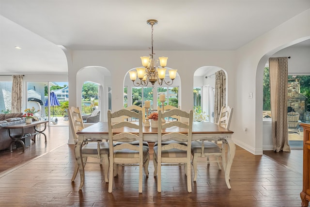 dining space featuring dark wood-type flooring and a chandelier