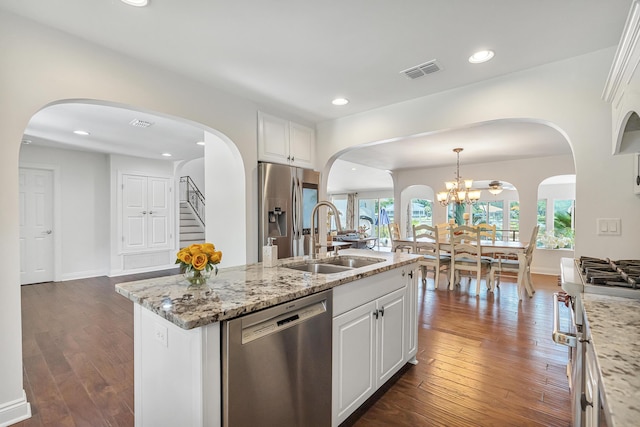 kitchen with white cabinetry, sink, stainless steel appliances, and a center island with sink