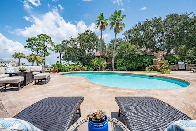 view of swimming pool featuring a patio and an outdoor living space with a fireplace