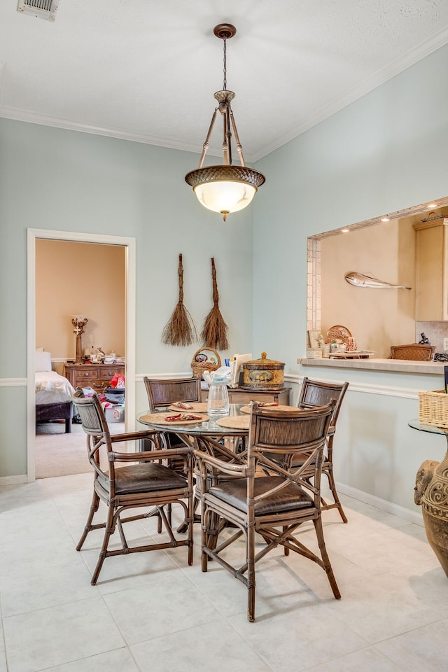 dining room with crown molding and light tile patterned floors