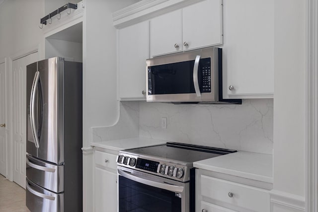 kitchen with tasteful backsplash, appliances with stainless steel finishes, and white cabinets