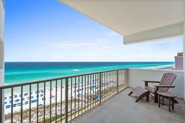 balcony featuring a water view and a beach view