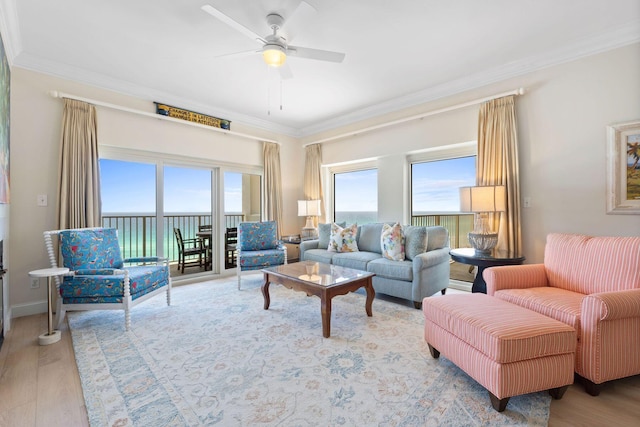 living room featuring light hardwood / wood-style flooring, a healthy amount of sunlight, ceiling fan, and crown molding