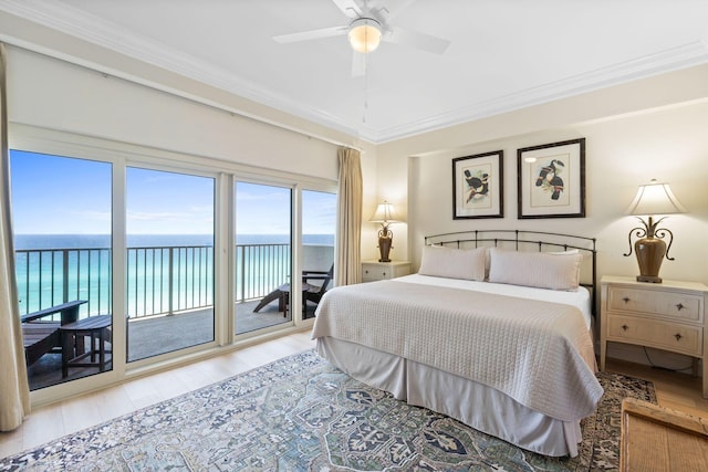 bedroom with multiple windows, a water view, ceiling fan, and access to outside