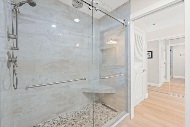 bathroom with hardwood / wood-style flooring and an enclosed shower