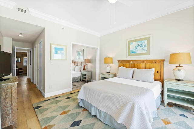 bedroom featuring crown molding, light hardwood / wood-style floors, and ceiling fan