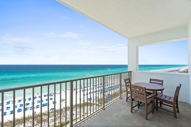 balcony featuring a water view and a beach view