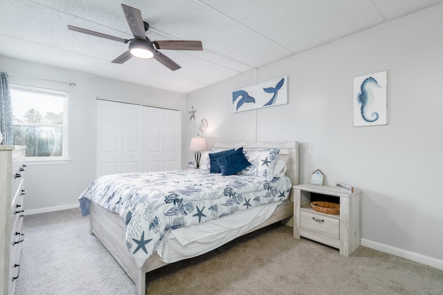 carpeted bedroom featuring a closet, a textured ceiling, and ceiling fan