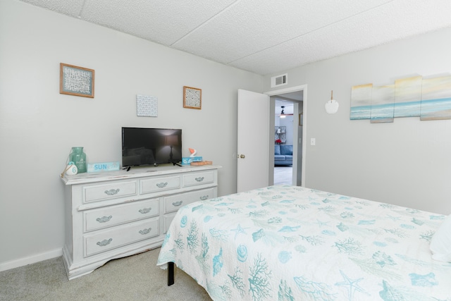 carpeted bedroom featuring a paneled ceiling