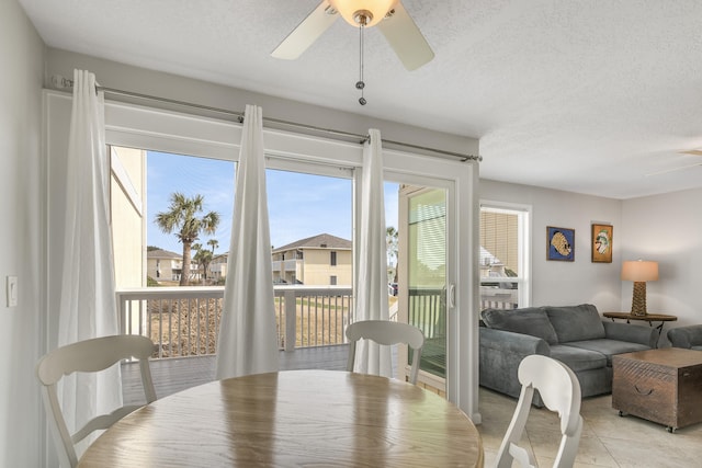 dining room with ceiling fan, light tile floors, and a textured ceiling