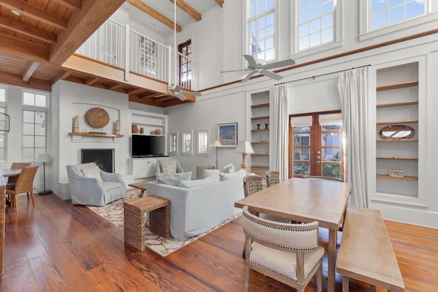 living room featuring a healthy amount of sunlight, dark wood-type flooring, ceiling fan, and a fireplace