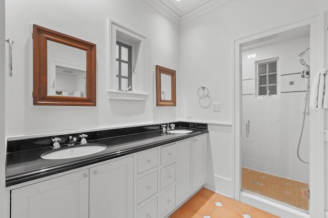 bathroom featuring vanity with extensive cabinet space, a shower with door, ornamental molding, double sink, and tile flooring