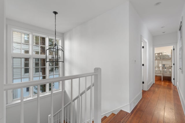 hall featuring a chandelier and wood-type flooring