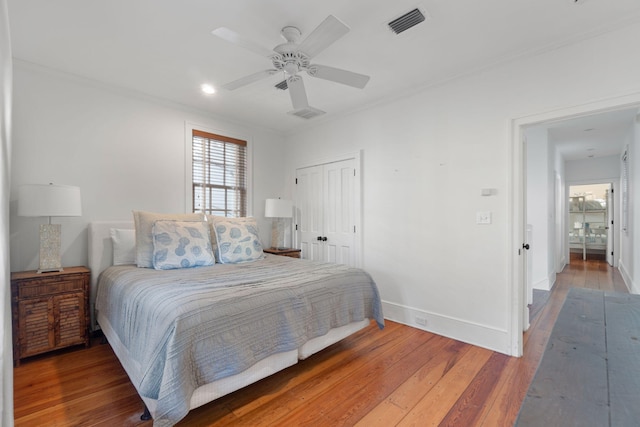 bedroom featuring a closet, dark hardwood / wood-style floors, and ceiling fan