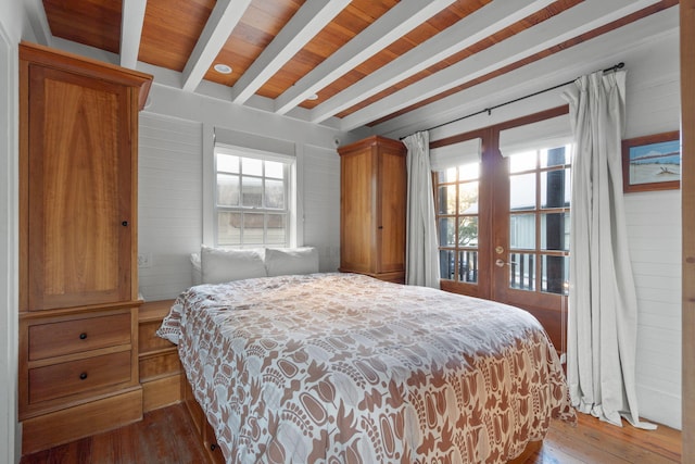 bedroom with dark hardwood / wood-style flooring, beam ceiling, and multiple windows