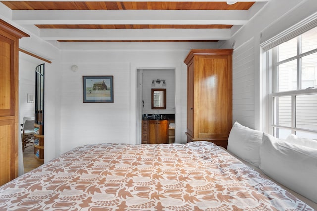 bedroom featuring beam ceiling and hardwood / wood-style floors