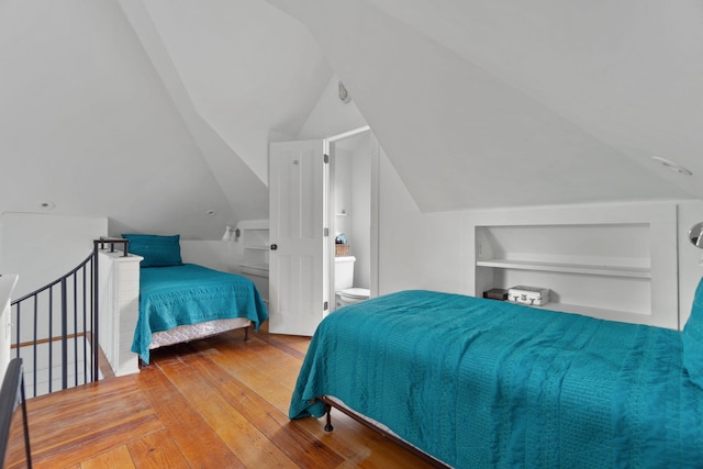 bedroom with vaulted ceiling and light wood-type flooring