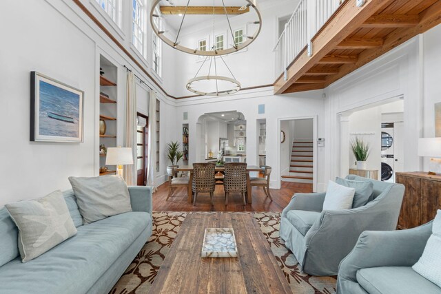 16 S Green Turtle Ln, Inlet Beach, FL 32461 - living room featuring arched walkways, stairway, stacked washing maching and dryer, and hardwood / wood-style flooring