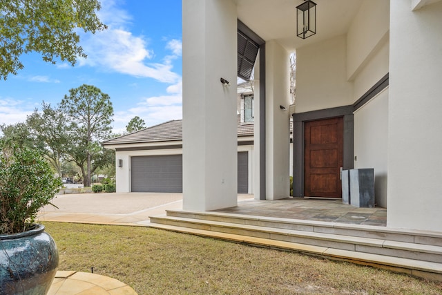 doorway to property featuring a yard and a garage