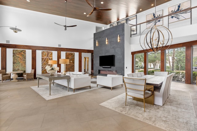 living room featuring light tile flooring, a tiled fireplace, a high ceiling, ceiling fan with notable chandelier, and wood ceiling