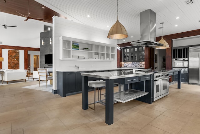 kitchen featuring ceiling fan, light tile floors, high end appliances, decorative light fixtures, and island exhaust hood