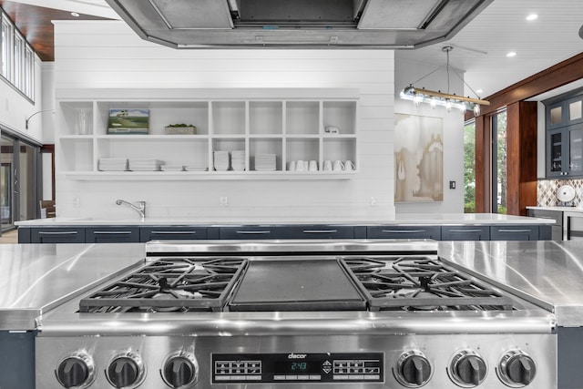 interior space featuring stainless steel counters, range, and decorative light fixtures