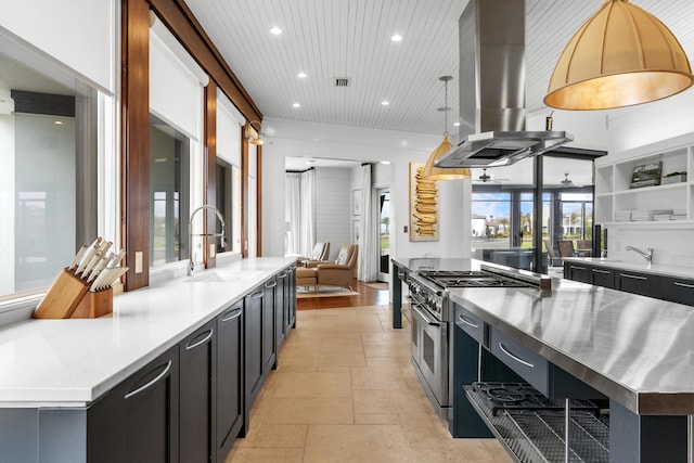 kitchen featuring range with two ovens, a kitchen island, stainless steel counters, island range hood, and light tile floors