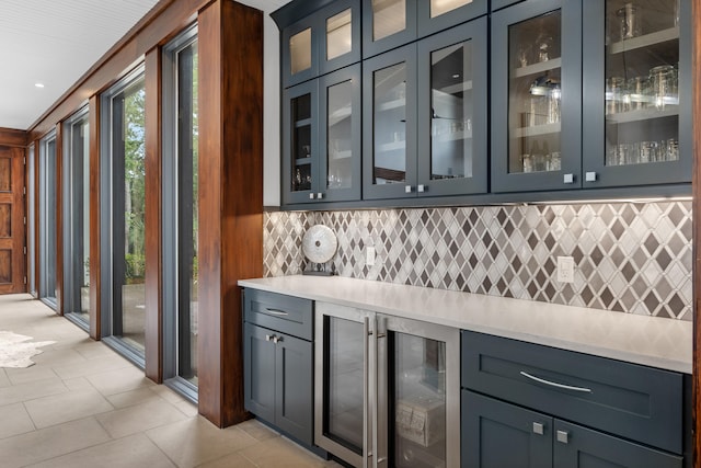 bar featuring backsplash, wine cooler, and light tile flooring