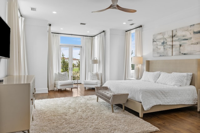 bedroom featuring ceiling fan, dark hardwood / wood-style floors, and multiple windows