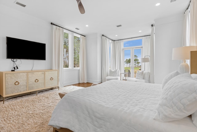 bedroom with light hardwood / wood-style flooring, ceiling fan, and multiple windows