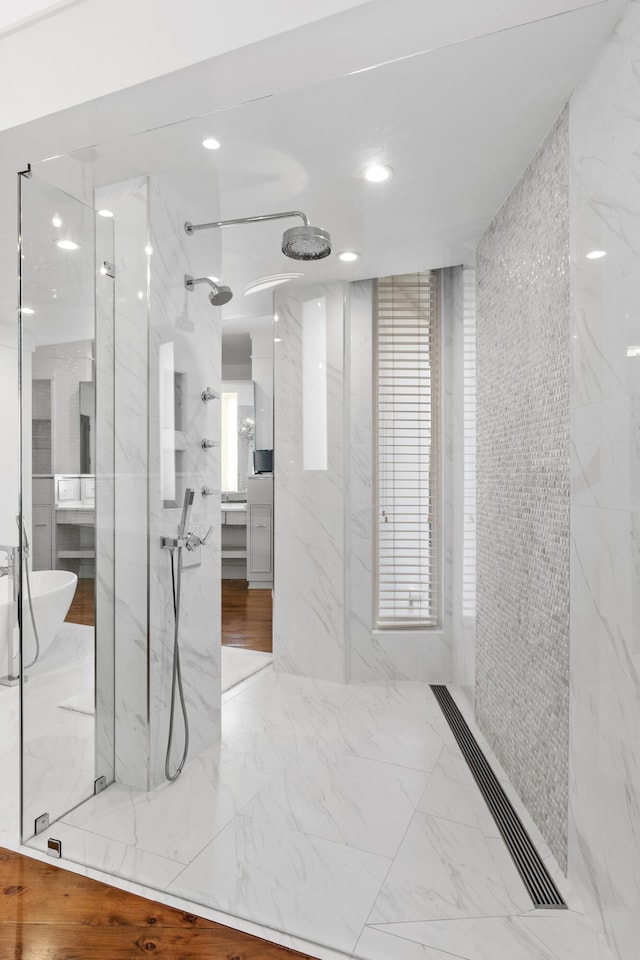 bathroom with tiled shower and tile floors