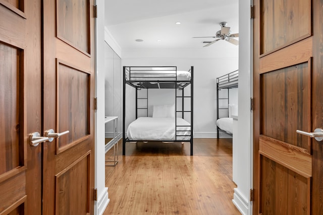 bedroom with crown molding, light hardwood / wood-style flooring, and ceiling fan